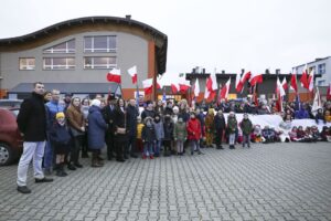 Na zdjęciu grupa osób z flagami Polski uczestnicząca w obchodach 11 listopada